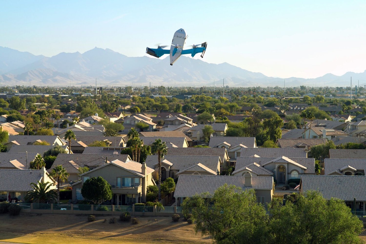 Amazon delivery drone pictured above a row of houses and trees