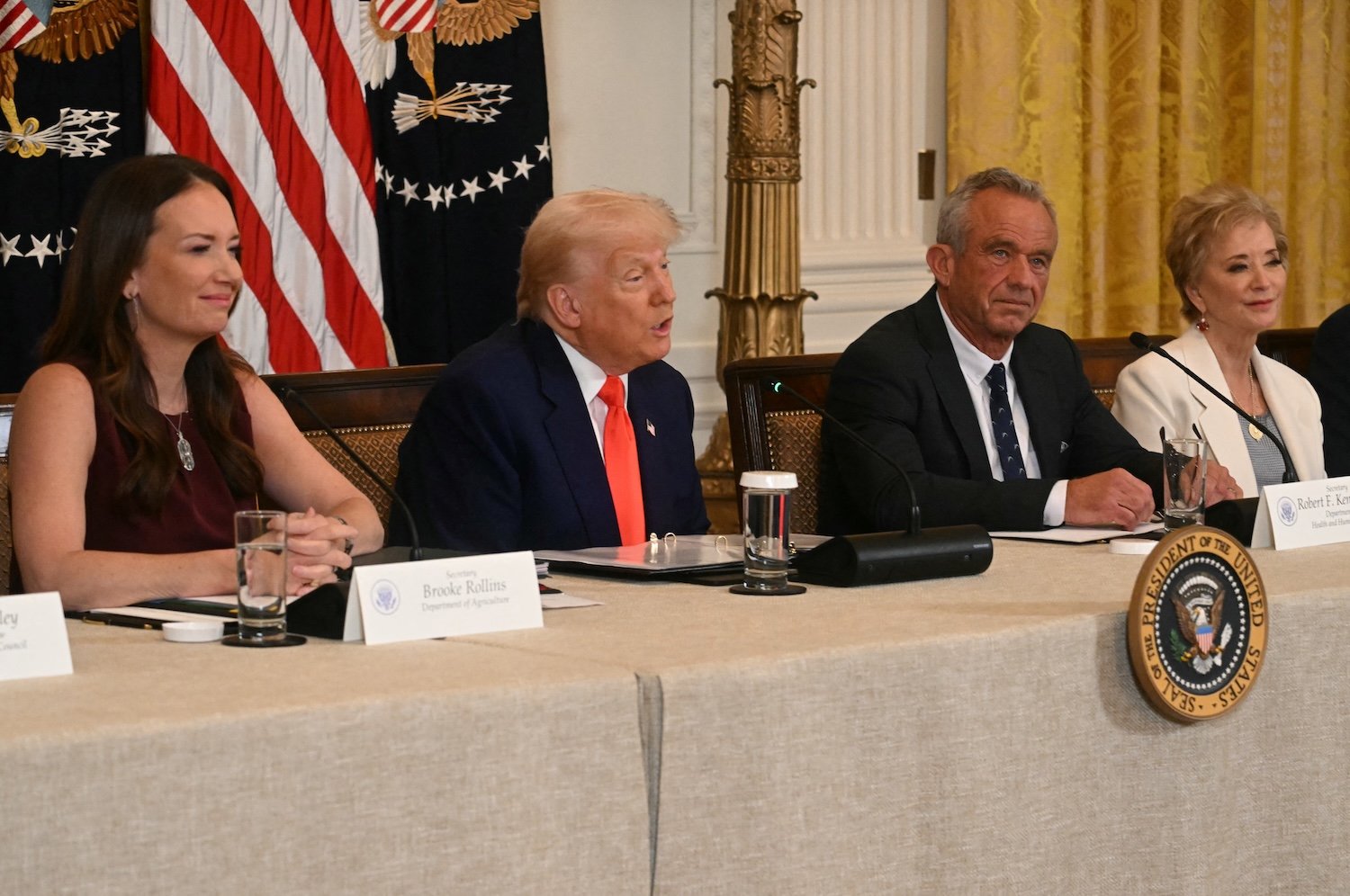 President Donald Trump speaks as US Secretary of Agriculture Brooke Rollins (L), US Secretary of Health and Human Services Robert F. Kennedy Jr. (2R), and US Secretary of Education Linda McMahon look on during a MAHA (Make America Healthy Again) Commission Event in the White House in Washington, DC, on May 22, 2025.