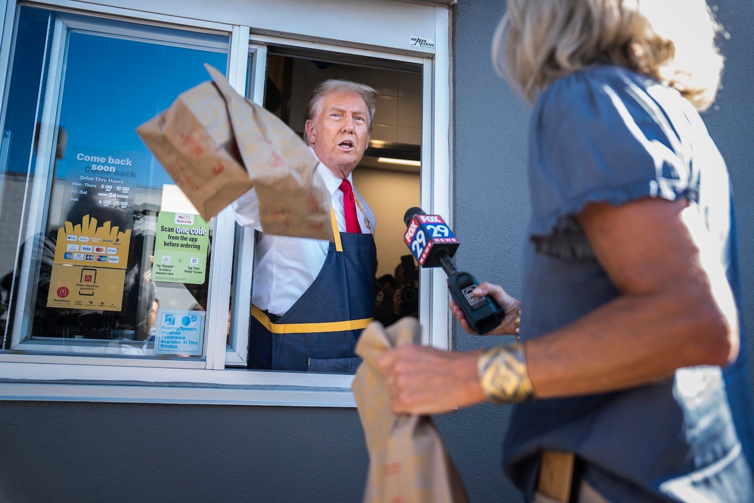 President Trump handing out a McDonald's order through the serving window.