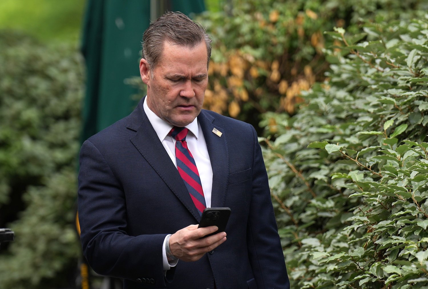 National Security Advisor Michael Waltz looks at his phone as he prepares for a TV interview at the White House on May 1, 2025 in Washington, DC.