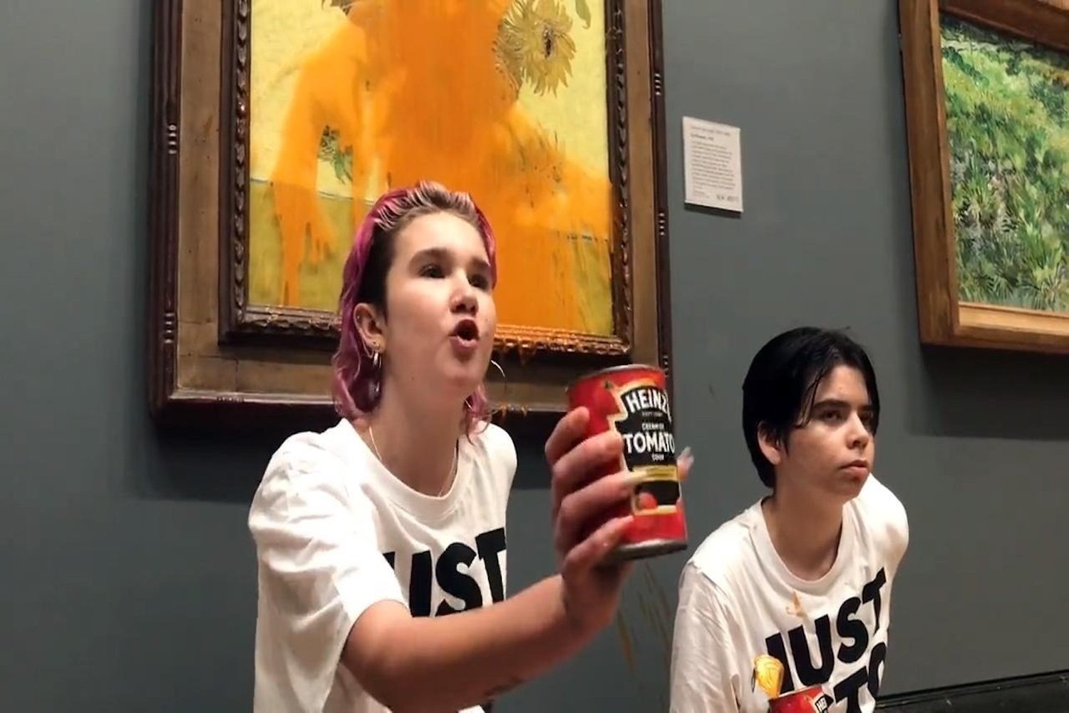 Protesters stand in front of Van Gogh painting