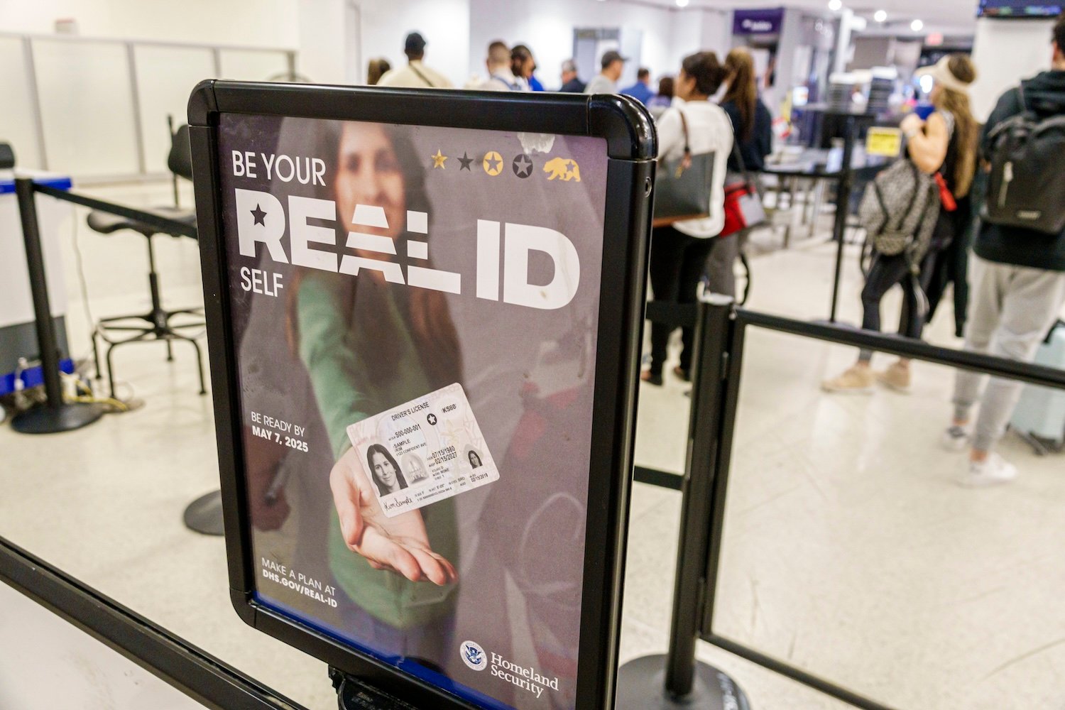 Miami International Airport TSA checkpoint security screening with a Real ID sign.